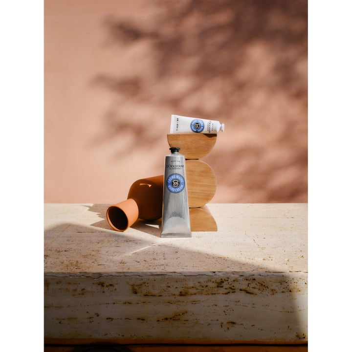 L'Occitane Shea Butter Hand Cream 30 ml återfuktande 20% sheasmör kräm i tuber på träblock med mjuka skuggor.