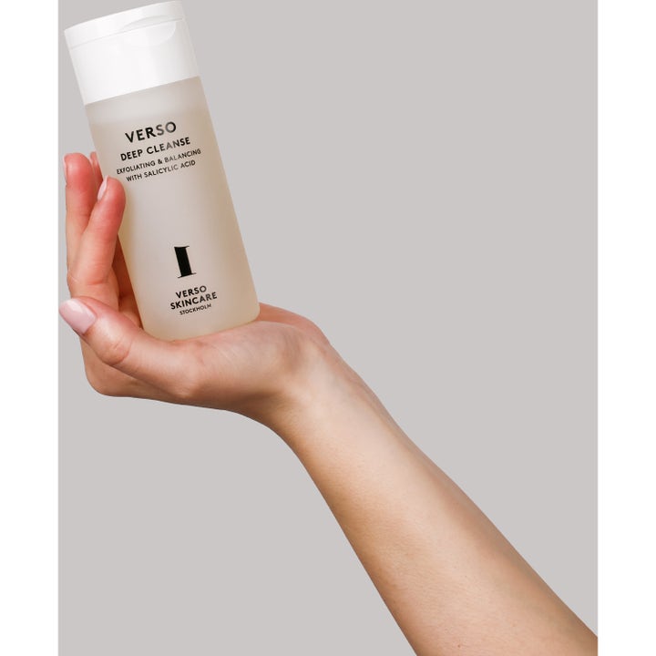 Verso Deep Cleanse 150 ml exfolierande ansiktsrengöring i frostad flaska som hålls i en hand