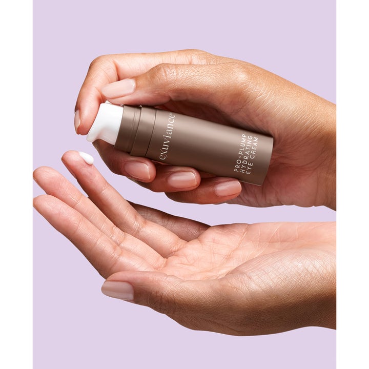 Exuviance Pro-Plump Hydrating Eye Cream 15 g återfuktande ögonkräm i bronsfärgad flaska som pumpas ut på ett finger.