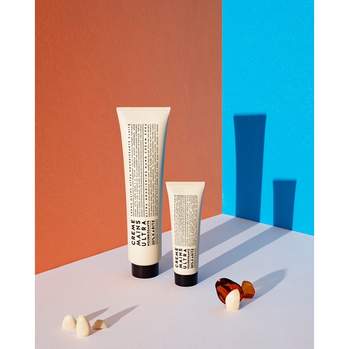 Compagnie de Provence handkräm 20% karité 100 ml ger fukt i vita tuber mot en modern orange och blå bakgrund.