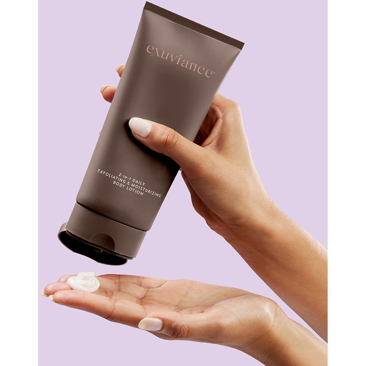Exuviance 2 in 1 Daily Body Lotion 177 ml, en 2-i-1 återfuktande bodylotion där vit kräm trycks ut från en brun tub.
