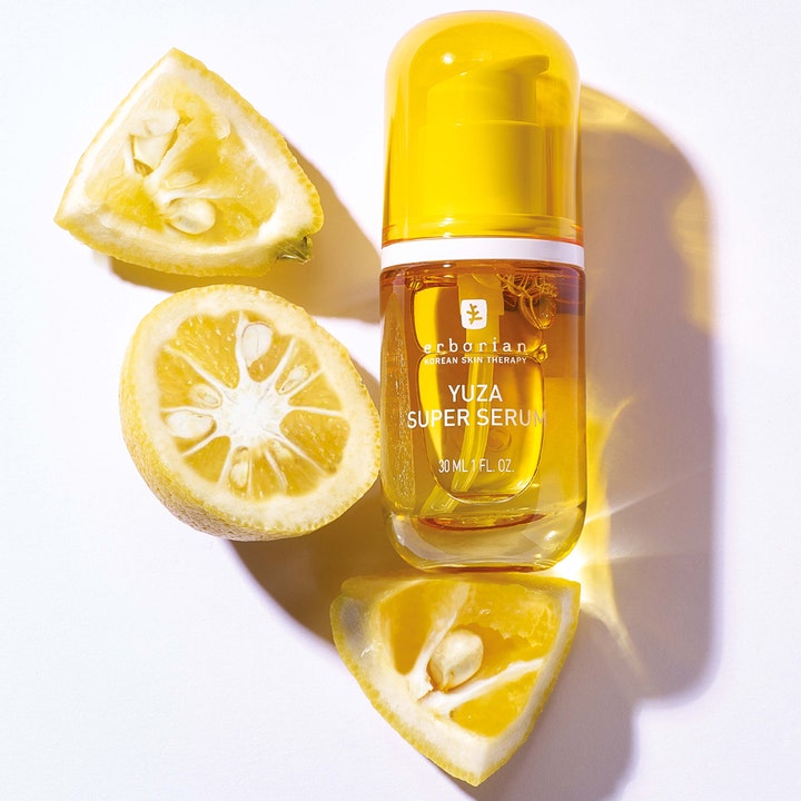 Erborian Yuza Super Serum 30 ml lystergivande yuzu super serum i gul flaska bredvid färsk yuzufrukt.
