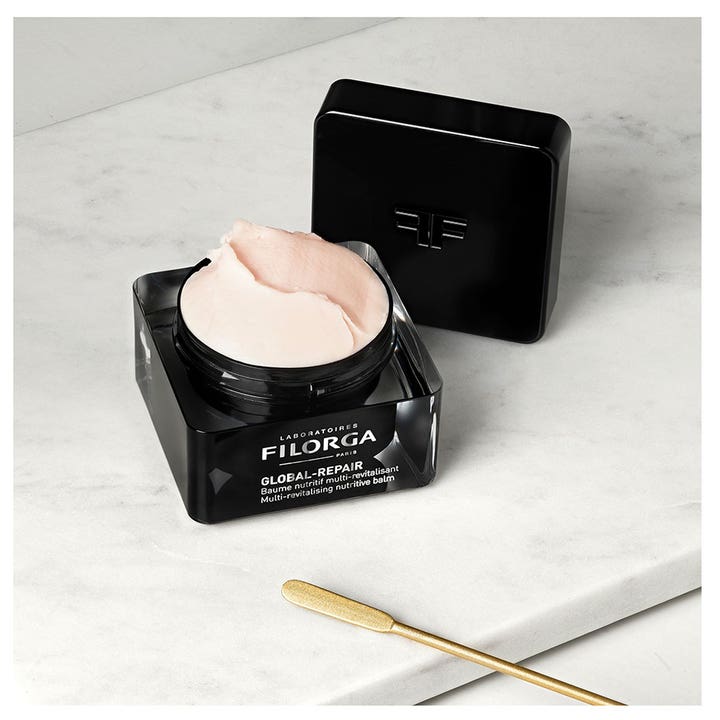 FILORGA Global-Repair Balm 50 ml antiaging ansiktskräm med rik ljusrosa textur i svart burk med guldspatel