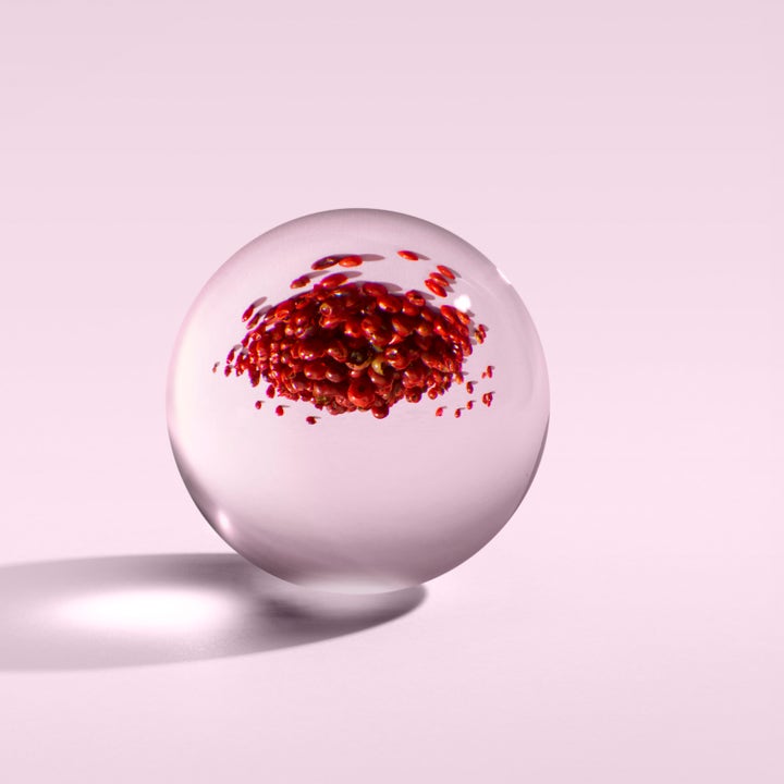 Molton Brown Fiery Pink Pepper 300 ml återfuktande handkräm med röda rosépepparkorn inuti en dekorativ glaskula.