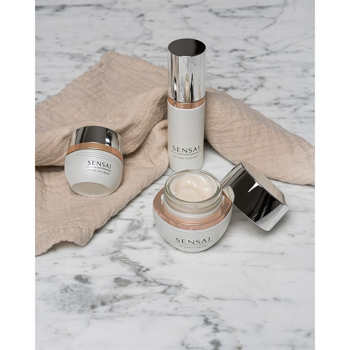 Sensai Cellular Performance Lifting Eye Cream 15 ml lyftande ögonkräm i vit burk på marmoryta med krämig textur