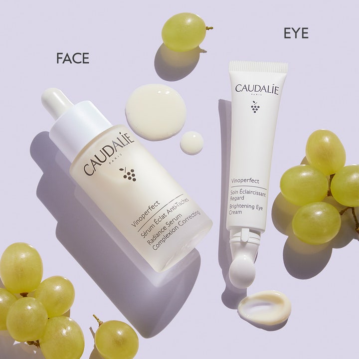 Caudalie Vinoperfect Brightening Eye Cream 15 ml lyxig ögonkräm mot mörka ringar bredvid serum och gröna druvor