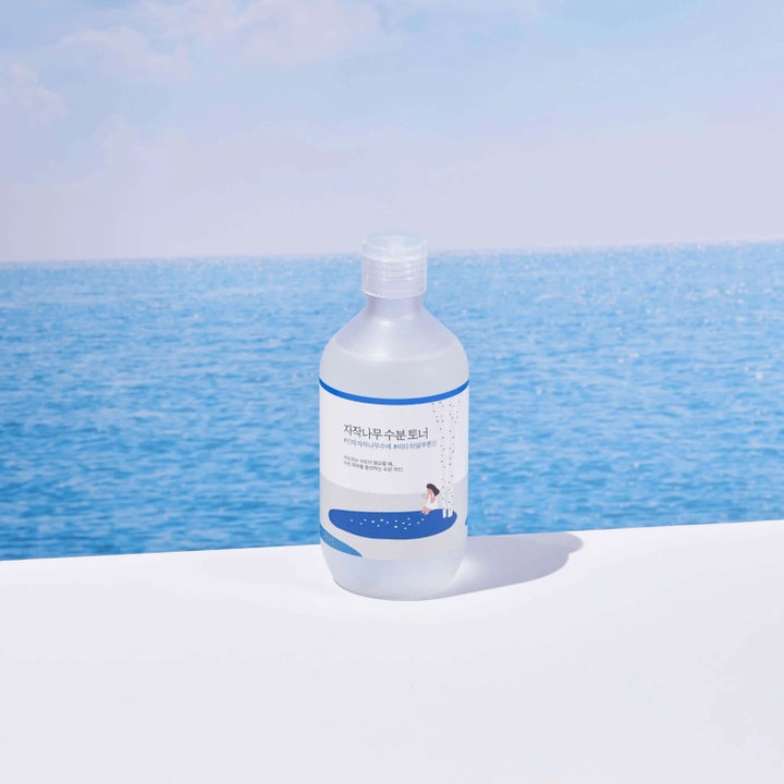 Round Lab Birch Juice Moisturizing Toner 300 ml återfuktande björksav ansiktsvatten framför en blå havshorisont.