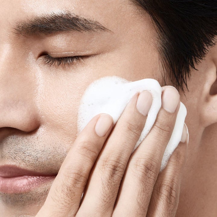 Shiseido Energistart 255 ml hudvård som ger energi när vitt rengöringsskum appliceras på en mans kind.