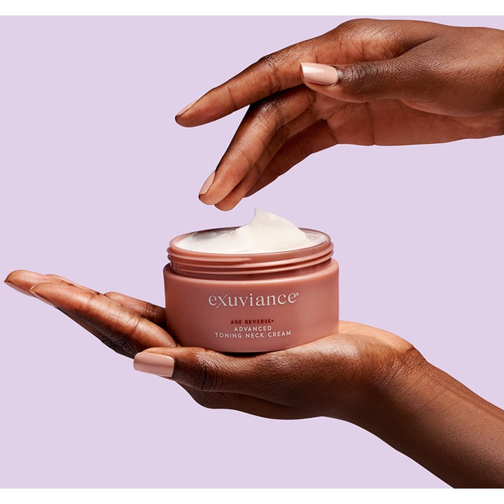 Exuviance Age Reverse Toning Neck Cream 125 g uppstramande halskräm i beige burk med krämig vit formula i händerna.