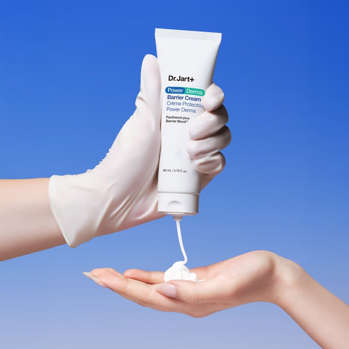 Dr.Jart+ Power Derma Barrier Cream 80 ml stärkande dagkräm trycks ut från en vit tub av en handske i en handflata.