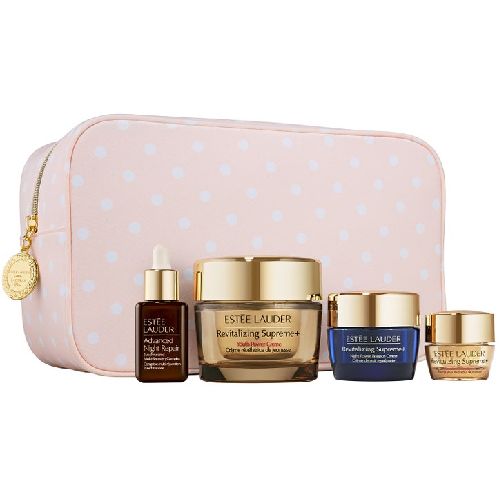 Estée Lauder gåvoset med antiaging ansiktsvård i fyra delar framför en rosa prickig necessär för lyxig premiumvård