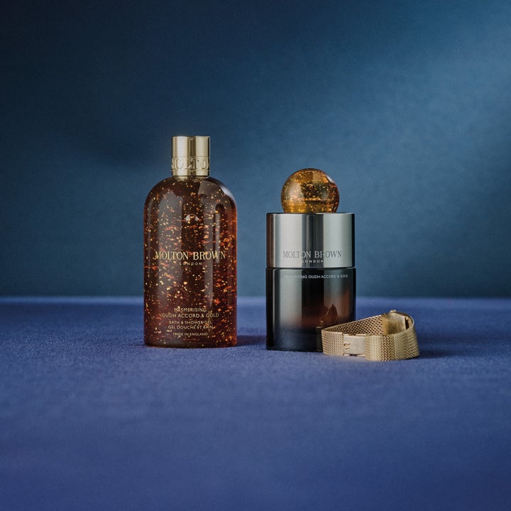 Molton Brown Mesmerising Oudh Accord & Gold 300 ml premium duschtvål med guld och oud doft intill parfymflaska.