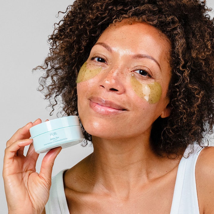 PÜR Mellow Eyes Rejuvenating Eye Patches 90 g återfuktande hydrogel eye patches på kvinna som håller ljusblå burk
