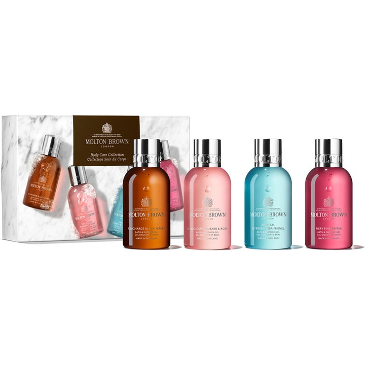 Molton Brown presentset 4x100ml med molton brown rhubarb and rose duschgel i färgglada flaskor framför en vit marmorerad ask.