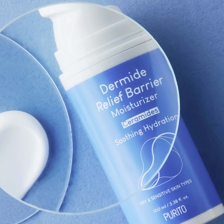 Purito Dermide Relief Barrier Moisturizer 100 ml barriärstärkande kräm ceramider visar vit textur bredvid blå flaska.
