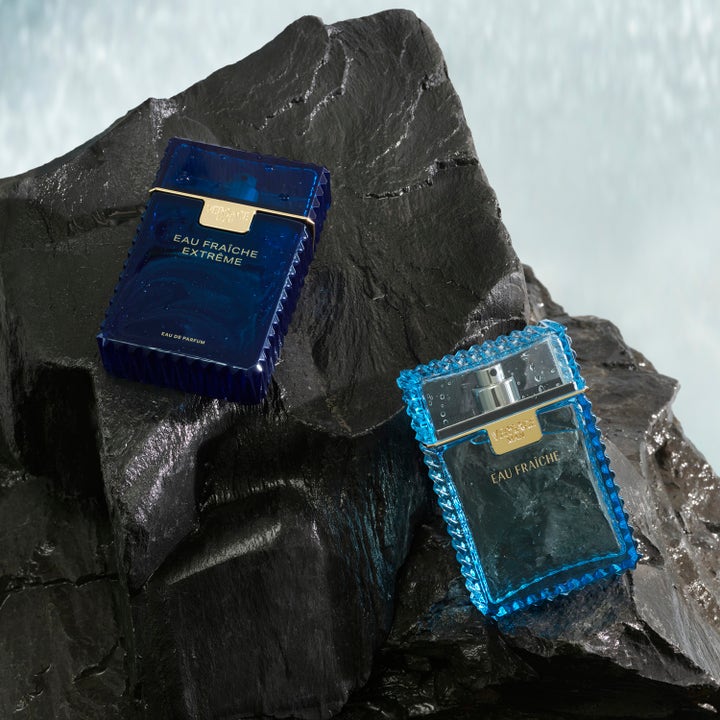 Versace Eau Fraiche Extreme 250 ml duschtvål med blå räfflade flaskor på våta mörka klippor vid vatten
