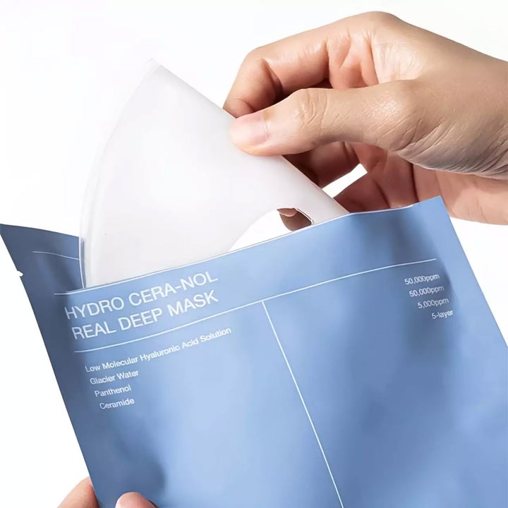 Biodance Hydro Cera-Nol Real Deep Mask 1 st återfuktande ansiktsmask där en hand lyfter en vit mask ur en blå förpackning