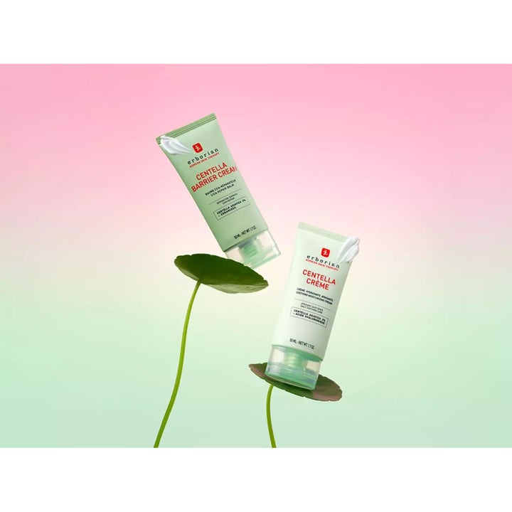 Erborian Centella Creme 50 ml återfuktande ansiktskräm i ljusgröna tuber placerade på blad mot en rosa bakgrund.
