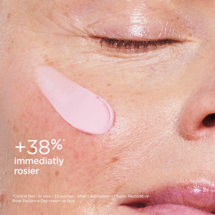Clarins Rose Radiance 50 ml uppstramande dagkräm med lyster applicerad som rosa klick på kinden