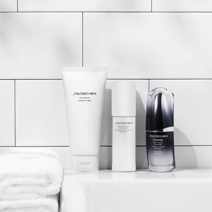 Shiseido Men Energizing Moisturizer Fluid 100 ml fuktkräm män i vit pumpflaska framför ljust kakel i badrum.