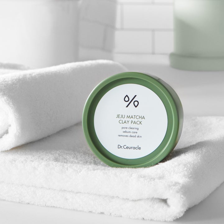 Dr. Ceuracle Jeju Matcha Clay Mask 115 g är en clay mask för pormaskar i grön burk placerad på en vit handduk.