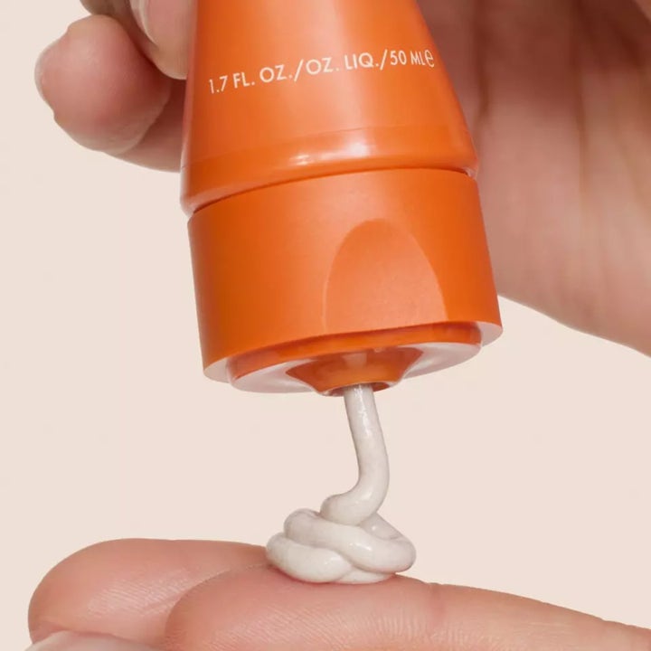 Origins GinZing SPF40 50 ml energigivande fuktkräm ansikte i orange tub med ljus krämig textur i vågigt mönster.