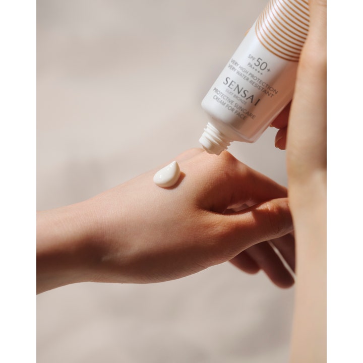 Sensai Silky Bronze Protective Cream Face 50 ml premium solkräm ansikte som ger skydd med krämig vit textur på hand.