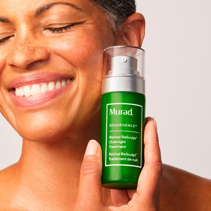 Murad Retinal ReSculpt Treatment 30 ml retinal serum i grön pumpflaska som hålls intill en leende kvinna