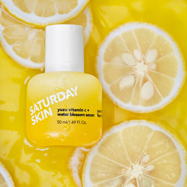 Saturday Skin Yuzu Vitamin C + Water Blossom Serum 50 ml ger lyster i gul flaska bland färska citrusskivor
