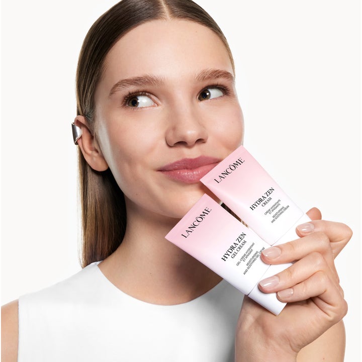 Lancôme Hydra Zen Anti-Stress Day Cream 30 ml återfuktande dagkräm i rosa tuber som hålls av en modell.