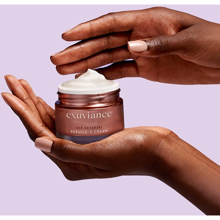 Exuviance Age Reverse + Rebuild-5 Cream 50 ml exuviance peptid kräm i öppen bronsburk som hålls i kupade händer.