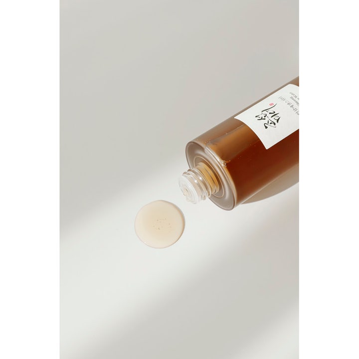 Beauty of Joseon Ginseng Essence Water återfuktande ansiktsvatten i brun flaska med en droppe på vit bakgrund.