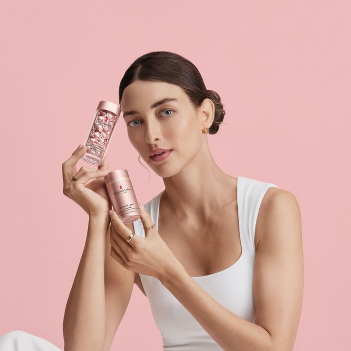 Elizabeth Arden Ceramide Retinol + Hpr 15 ml ögonkräm förnyar huden och hålls av kvinna mot rosa bakgrund.