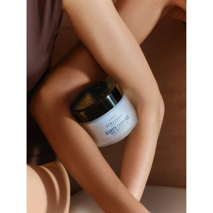 L'Occitane Shea Butter Ultra Rich Body Cream 200 ml ger hudvård med sheasmör i en burk som hålls mellan armar.