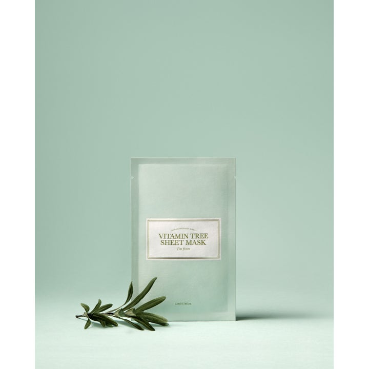 I'm from Vitamin Tree Sheet Mask 1 st lystergivande ansiktsmask i ljusgrön sachet bredvid en grön kvist.