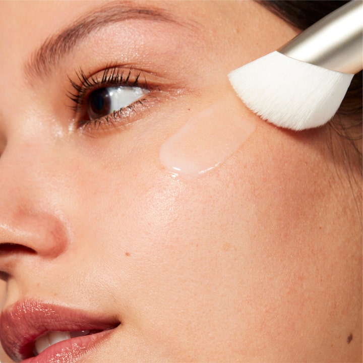MAC Cosmetics Serum + Moisturizer Brush 1 st serumborste med vita strån som applicerar serum på en kind.