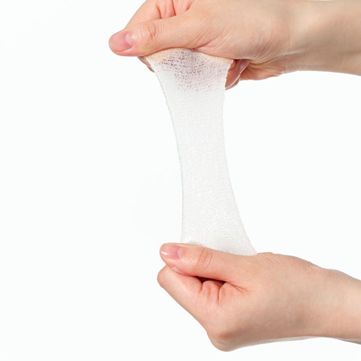 Dr. Ceuracle PLC Calming Solution Pad 130 st lugnande tonerpads visar en stretchig vit nätpad mellan händerna.