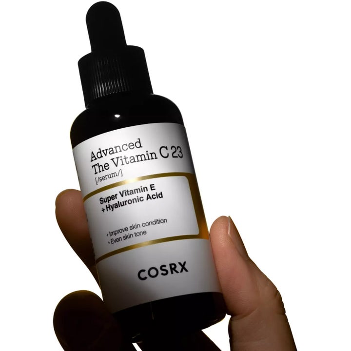 COSRX Advanced The Vitamin C 23 Serum 20 g i mörk glasflaska som hålls i en hand ger lyster.