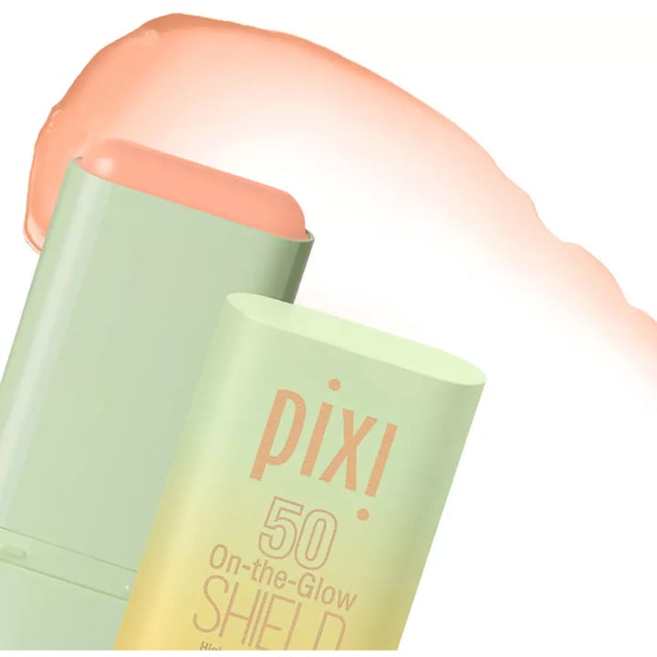 Pixi On-the-Glow Shield 19 g ger SPF 50 i ett ljusgrönt solstift visat med ett persikofärgat svep av texturen.