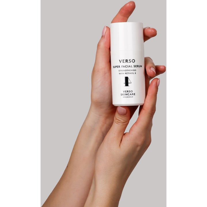 Verso Super Facial Serum 30 ml stärkande retinolserum i en vit pumpflaska som hålls i händerna.