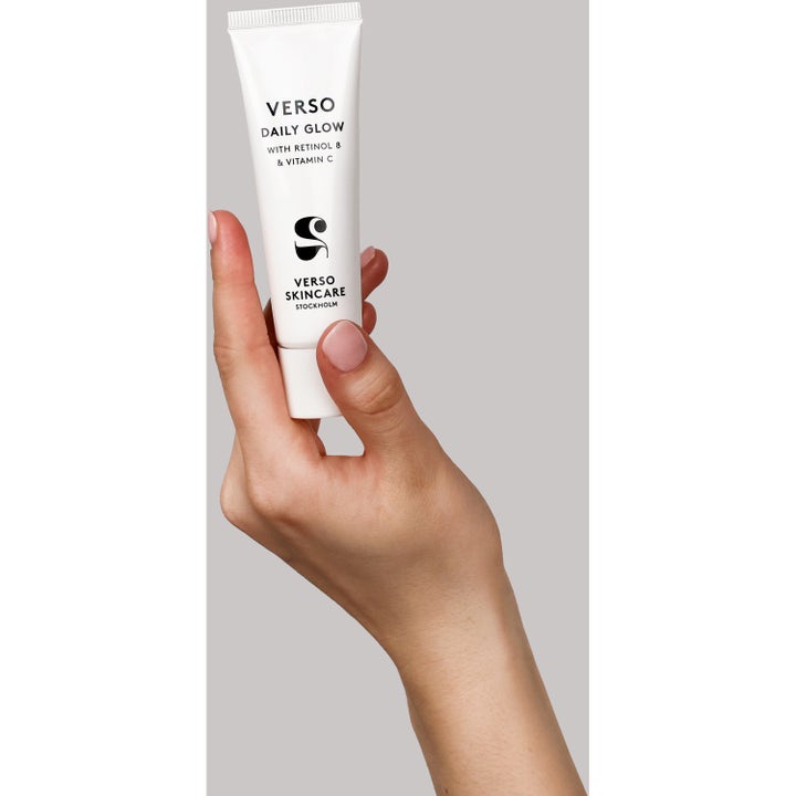 Verso Daily Glow 30 ml lystergivande serum med retinol 8 och vitamin C i vit tub hålls i en hand.