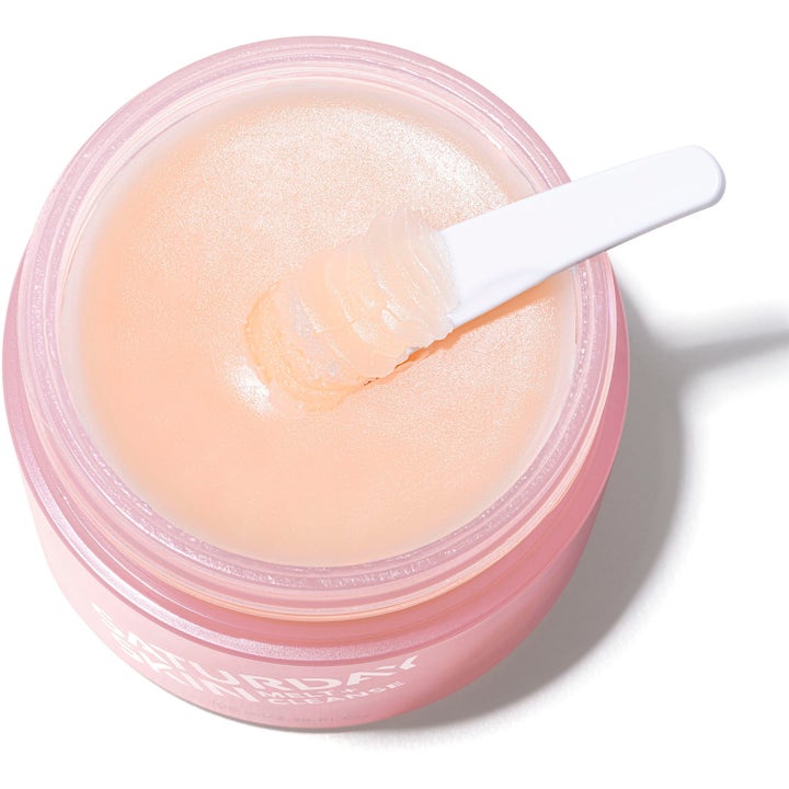Saturday Skin Melt + Cleanse Makeup Melting Balm 100 ml ansiktsrengöring i rosa burk med mjuk balm-textur och vit spatel.