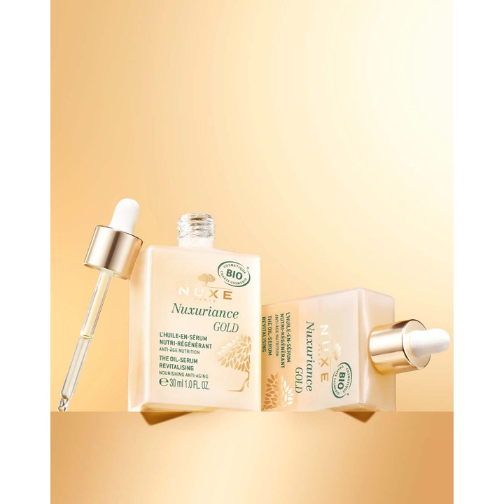 Nuxe Nuxuriance Gold 30 ml förnyande ansiktsserum i glasflaska med pipett på en gyllene bakgrund