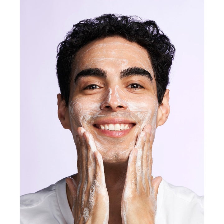 Exuviance Clarify & Glow Morning Ritual 212 ml djuprengöring ger lyster när en man applicerar vitt skum i ansiktet.