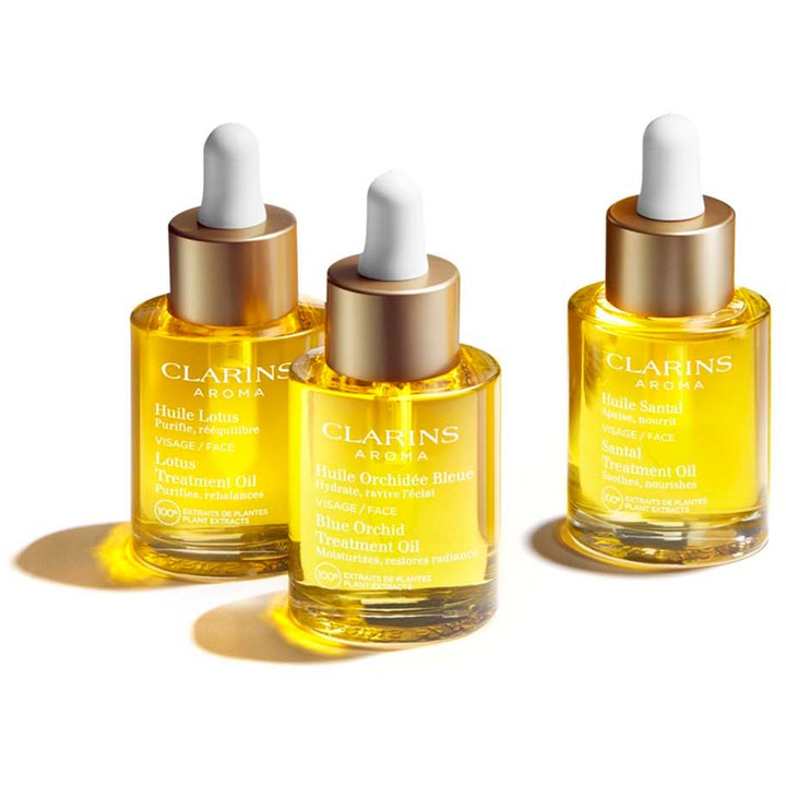 Clarins Santal Face Treatment Oil 30 ml lugnande ansiktsolja i tre glasflaskor med guldkork och vit pipett.