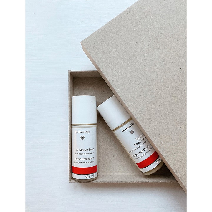 Dr. Hauschka Rose Deodorant 50 ml i glasflaska tillsammans med Sage Mint Deodorant i en beige pappkartong.