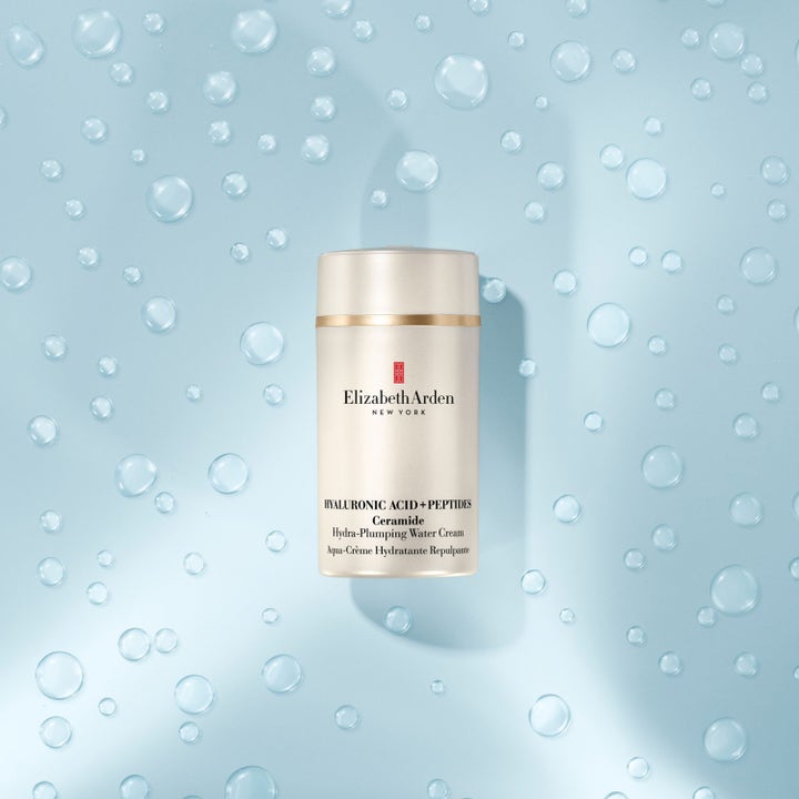 Elizabeth Arden Ceramide Hyaluronic Acid Water Cream 50 ml återfuktande dagkräm i champagnefärgad burk mot blått vatten.