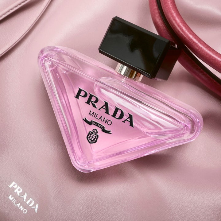 Prada Paradoxe Virtual Flower 30 ml blommig damparfym i trekantiga flaskor intill en svart handväska