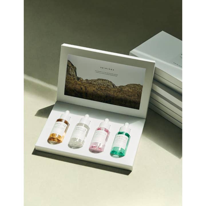 SKIN1004 Madagascar Centella Ampoule Kit 120 ml lugnande centella serum i en öppen vit box med fyra färgglada glasflaskor.