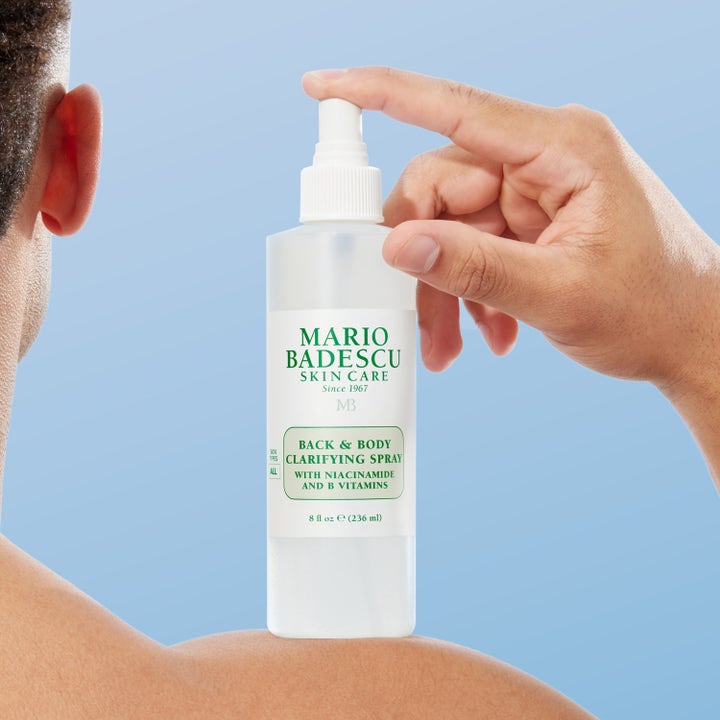 Mario Badescu Back And Body Clarifying Spray 236 ml med niacinamid i vit sprayflaska som hålls mot huden på en axel.
